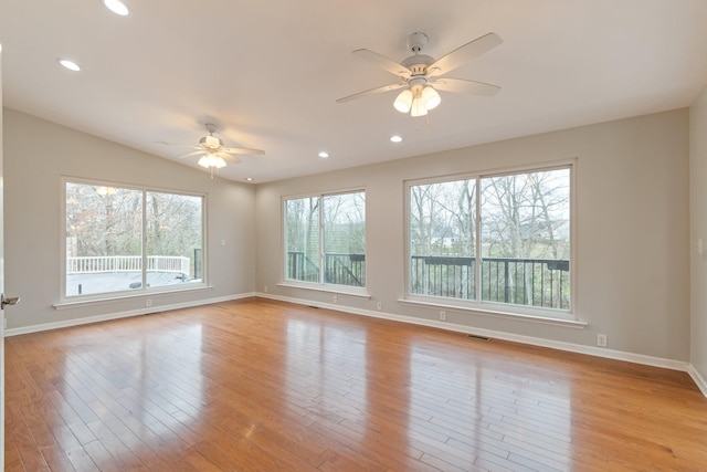 spare room with ceiling fan, a healthy amount of sunlight, light wood-type flooring, and lofted ceiling