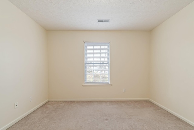 carpeted spare room with a textured ceiling