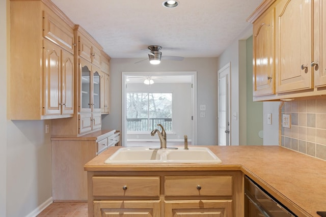 kitchen featuring ceiling fan, sink, stainless steel dishwasher, light brown cabinetry, and light tile patterned flooring