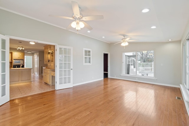 unfurnished room with vaulted ceiling, ceiling fan, light hardwood / wood-style flooring, and french doors