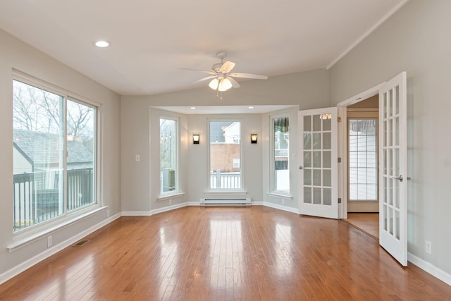 unfurnished room with french doors, light wood-type flooring, ceiling fan, and a baseboard heating unit