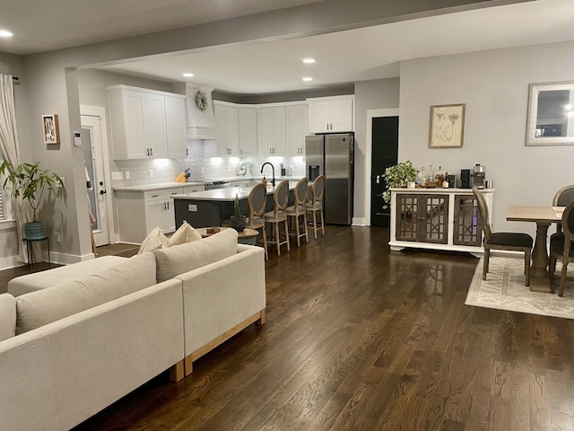 living room featuring sink and dark hardwood / wood-style floors