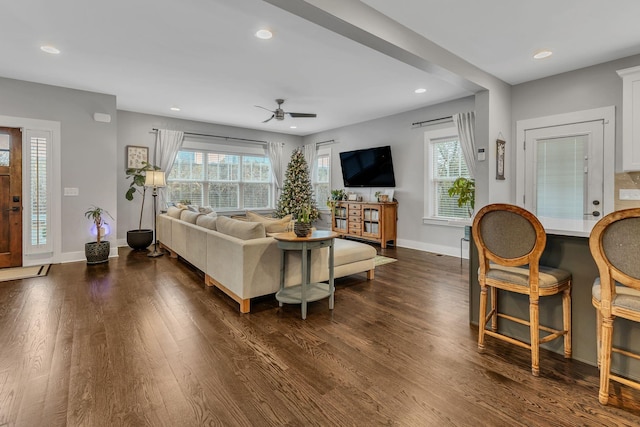 living room featuring a wealth of natural light, dark hardwood / wood-style flooring, and ceiling fan