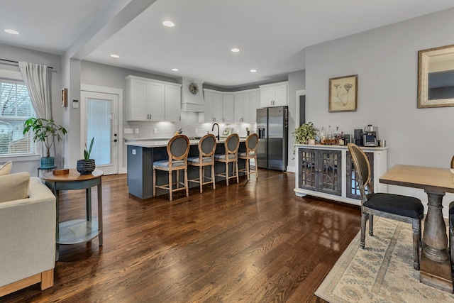 kitchen with dark hardwood / wood-style floors, a center island, white cabinetry, and stainless steel refrigerator with ice dispenser