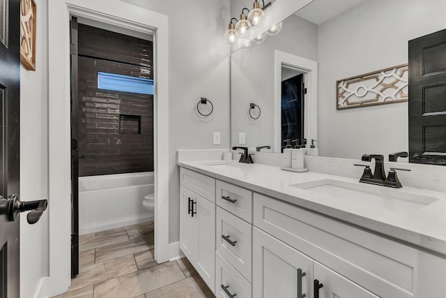 full bathroom with toilet, vanity, and tiled shower / bath