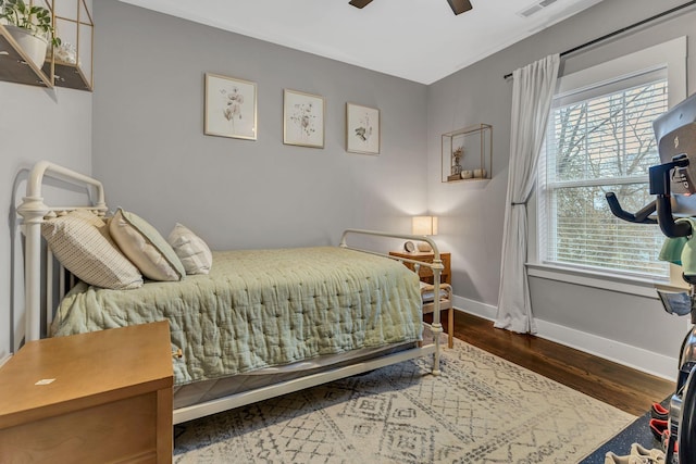 bedroom featuring ceiling fan, dark wood-type flooring, and multiple windows