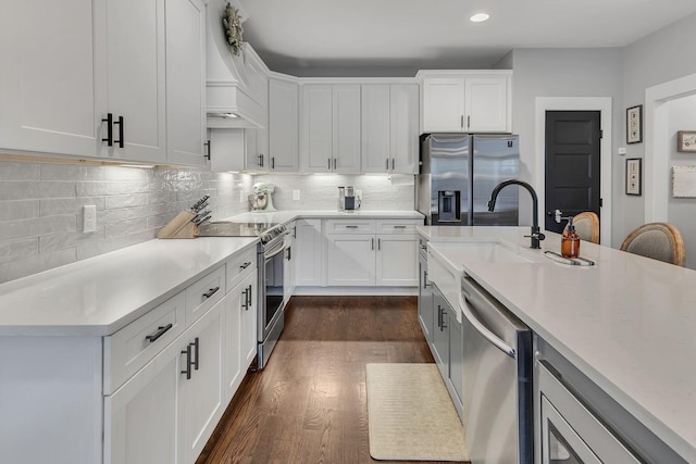 kitchen featuring sink, stainless steel appliances, dark hardwood / wood-style flooring, backsplash, and white cabinets