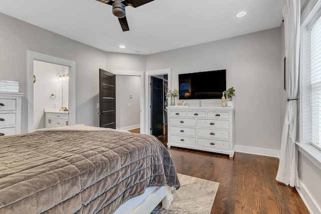 bedroom featuring connected bathroom, ceiling fan, dark wood-type flooring, and multiple windows