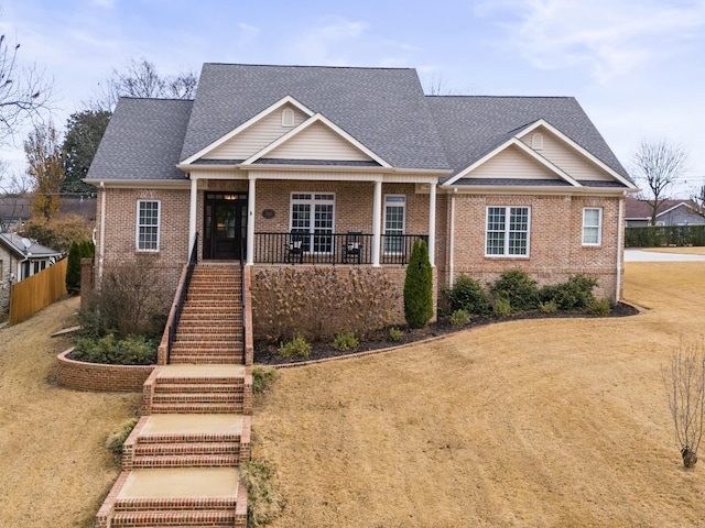 craftsman inspired home featuring covered porch and a front lawn