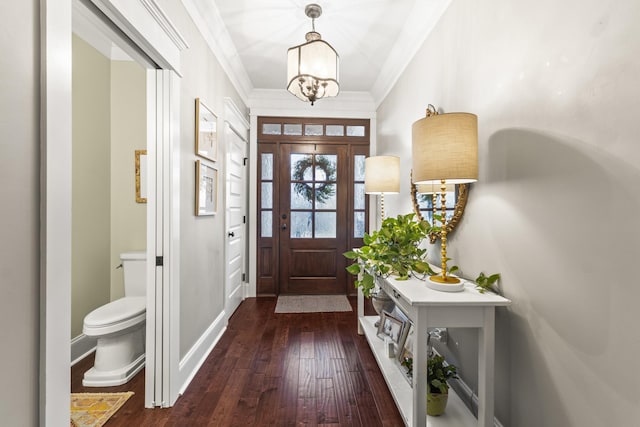 entrance foyer featuring dark hardwood / wood-style flooring, ornamental molding, and an inviting chandelier