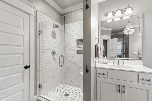 bathroom featuring vanity, an enclosed shower, and ornamental molding