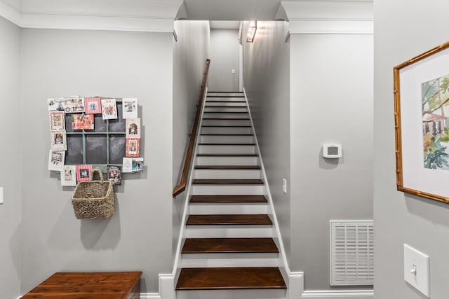 staircase featuring crown molding