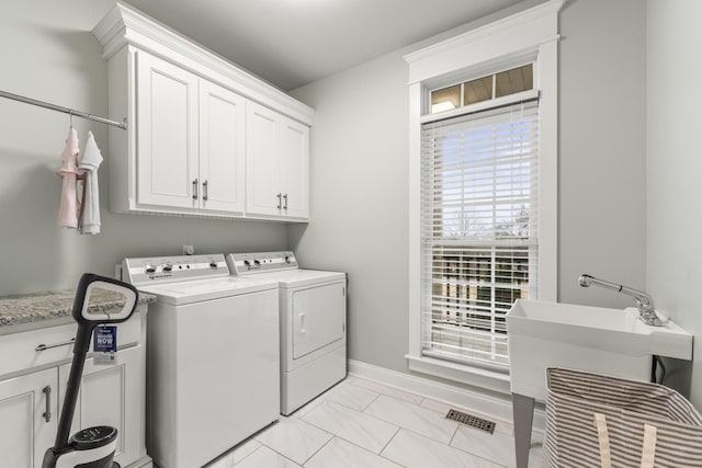 washroom featuring washing machine and clothes dryer and cabinets