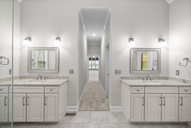 bathroom featuring ornamental molding, vanity, and a healthy amount of sunlight