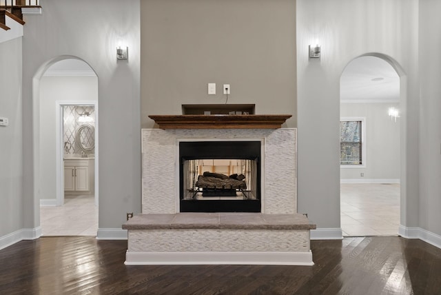 living room featuring hardwood / wood-style floors, a multi sided fireplace, and crown molding