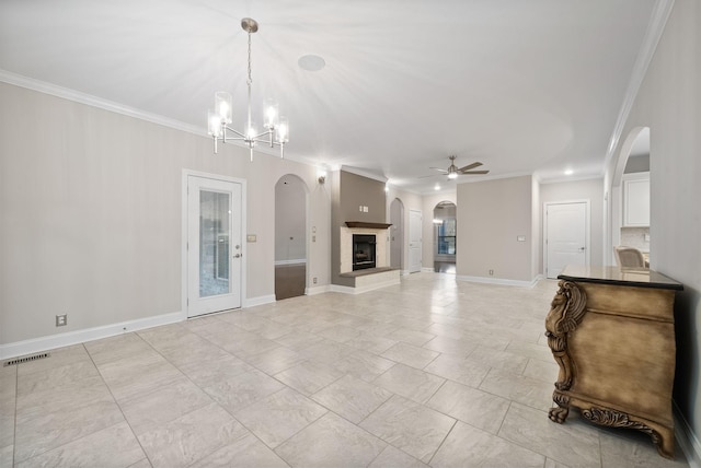 unfurnished living room featuring ceiling fan with notable chandelier and ornamental molding