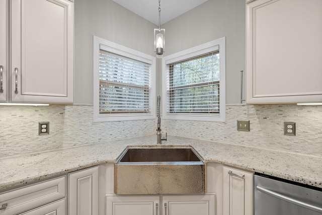 kitchen featuring white cabinets, sink, light stone countertops, and hanging light fixtures