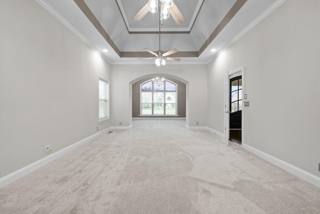 carpeted spare room featuring ceiling fan, a raised ceiling, and crown molding