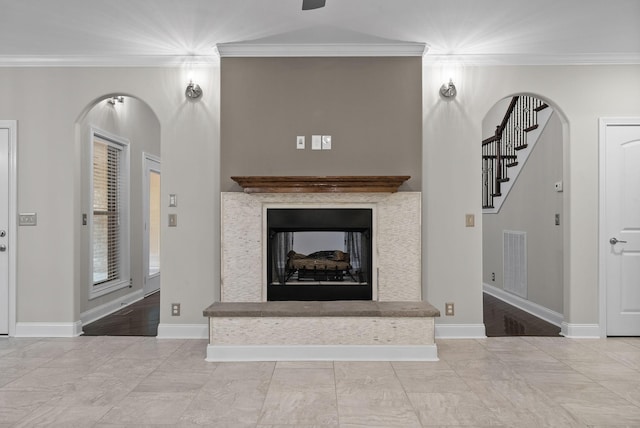 unfurnished living room with a multi sided fireplace and crown molding