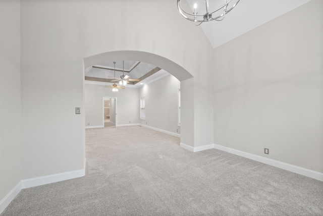 carpeted spare room with vaulted ceiling and ceiling fan with notable chandelier