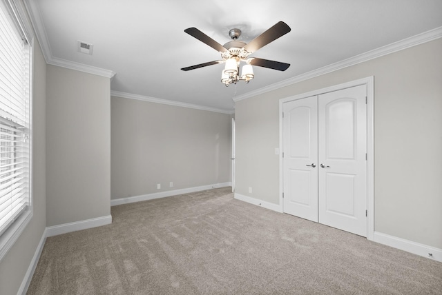 unfurnished bedroom with multiple windows, ceiling fan, and light carpet