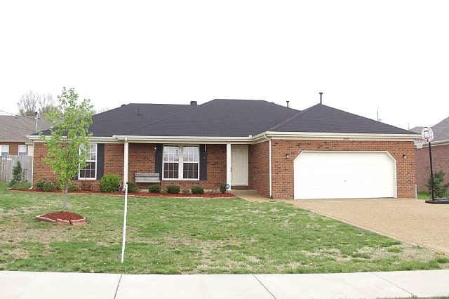 ranch-style home with a front yard and a garage