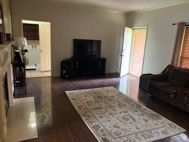 living room with dark hardwood / wood-style flooring, ornamental molding, and a textured ceiling