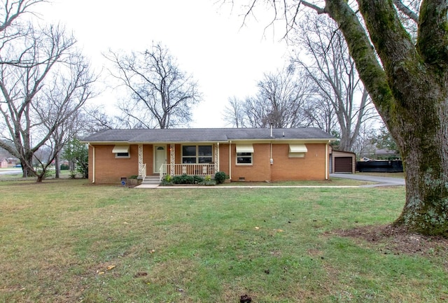 ranch-style home with covered porch, an outbuilding, a garage, and a front lawn