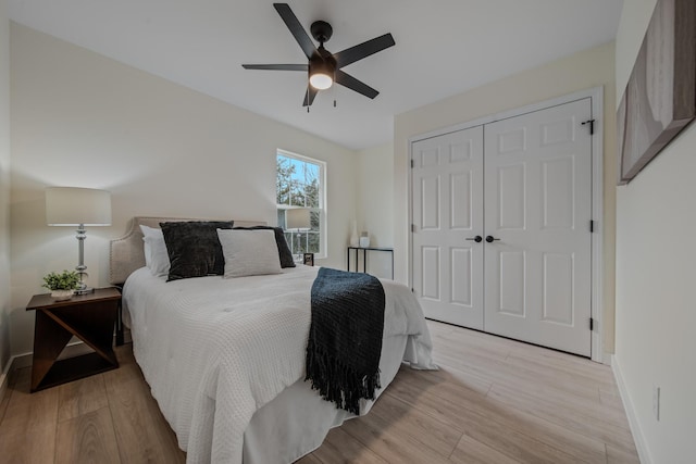 bedroom featuring light wood-type flooring, a closet, and ceiling fan