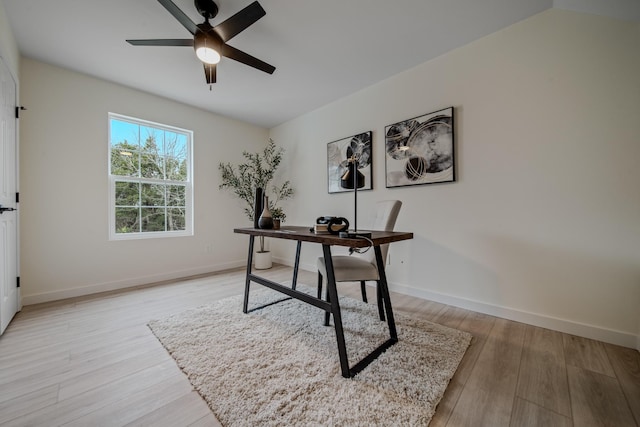 office area featuring ceiling fan, light wood-type flooring, and vaulted ceiling