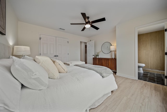 bedroom featuring a closet, ceiling fan, light hardwood / wood-style flooring, and ensuite bathroom