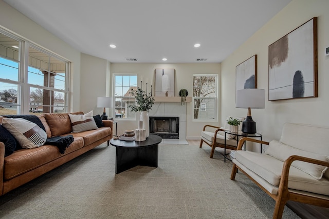 living room featuring a tile fireplace and light colored carpet