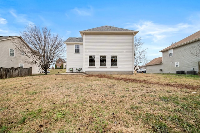 back of property featuring a yard and central air condition unit