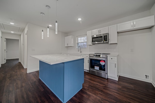 kitchen featuring appliances with stainless steel finishes, a kitchen island, dark hardwood / wood-style floors, white cabinetry, and hanging light fixtures