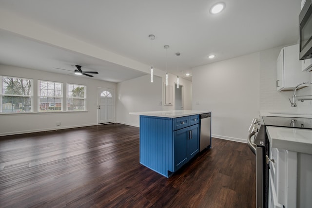 kitchen featuring white cabinets, blue cabinets, decorative light fixtures, a kitchen island, and dark hardwood / wood-style flooring