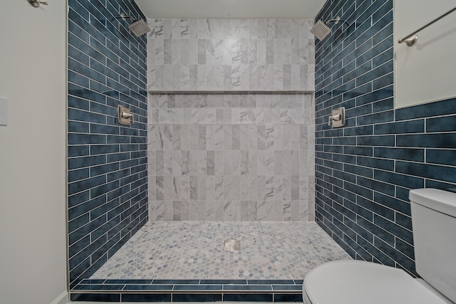 bathroom featuring a tile shower, toilet, and tile walls