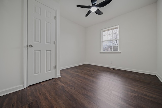 unfurnished bedroom with ceiling fan and dark wood-type flooring