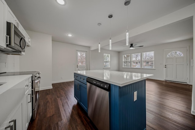 kitchen with stainless steel appliances, blue cabinets, a wealth of natural light, and ceiling fan