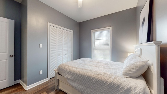 bedroom with dark hardwood / wood-style floors, ceiling fan, and a closet