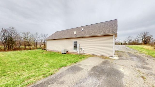 view of side of property with a lawn and central AC unit