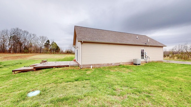 view of side of home with a lawn, cooling unit, and a deck