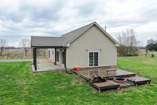 back of house featuring a yard and an outdoor fire pit