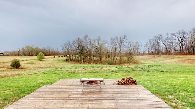 wooden terrace with a yard and a rural view