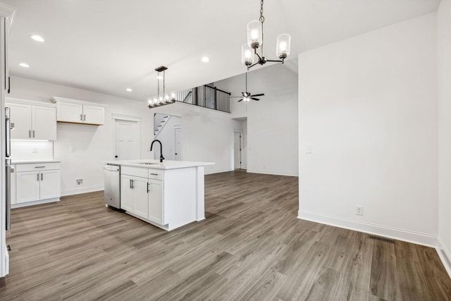 kitchen featuring white cabinetry, light hardwood / wood-style flooring, an island with sink, and sink