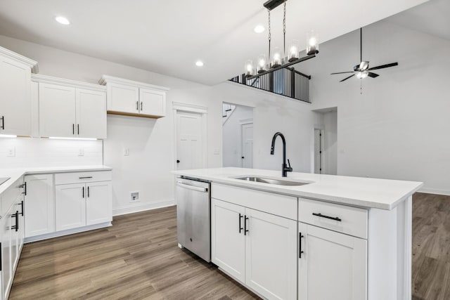 kitchen with wood-type flooring, white cabinetry, stainless steel dishwasher, and sink