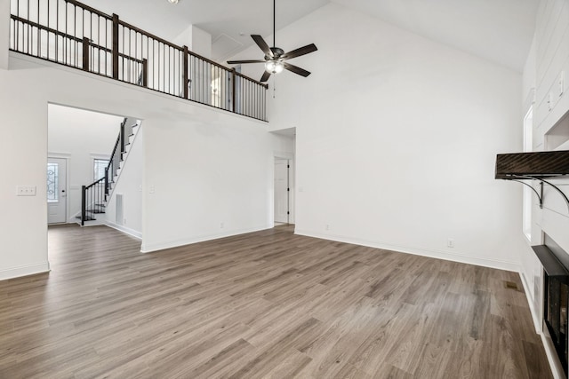 unfurnished living room featuring ceiling fan, light hardwood / wood-style flooring, and high vaulted ceiling