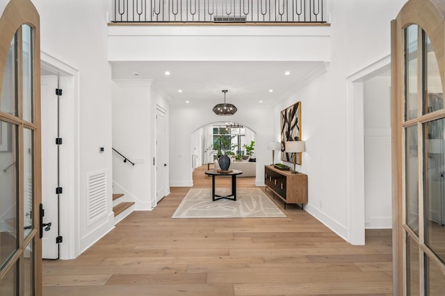 entrance foyer featuring light hardwood / wood-style floors and a high ceiling