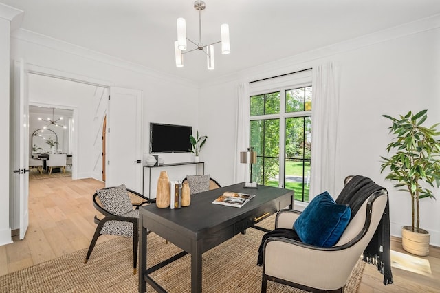 office space featuring a notable chandelier, ornamental molding, and light hardwood / wood-style flooring