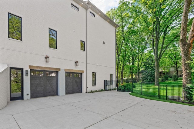 view of side of property featuring a lawn and a garage