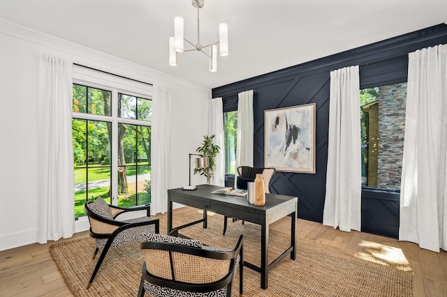 office featuring light hardwood / wood-style flooring, a notable chandelier, and ornamental molding